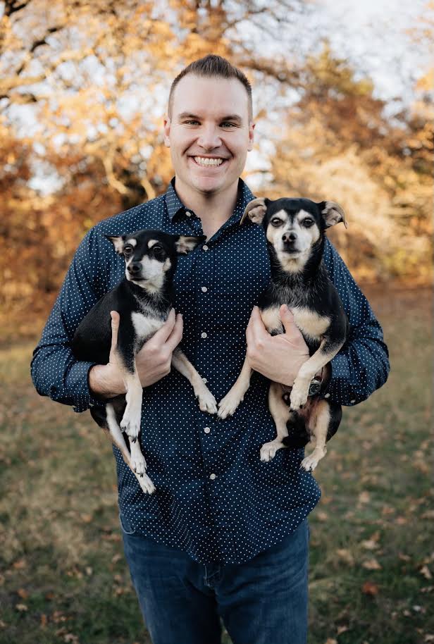 Zack Spears holding his two dogs, Vinny and Calvin, outdoors in North Texas